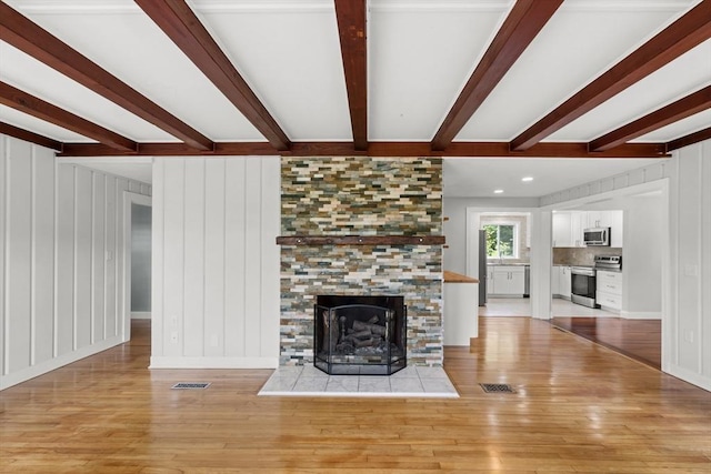 67 Great Neck Rd, Wareham, MA 02571 - unfurnished living room with beam ceiling, wood finished floors, and a tiled fireplace