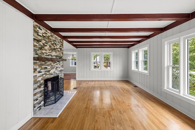 67 Great Neck Rd, Wareham, MA 02571 - unfurnished living room featuring hardwood / wood-style floors, beam ceiling, a tile fireplace, and baseboards