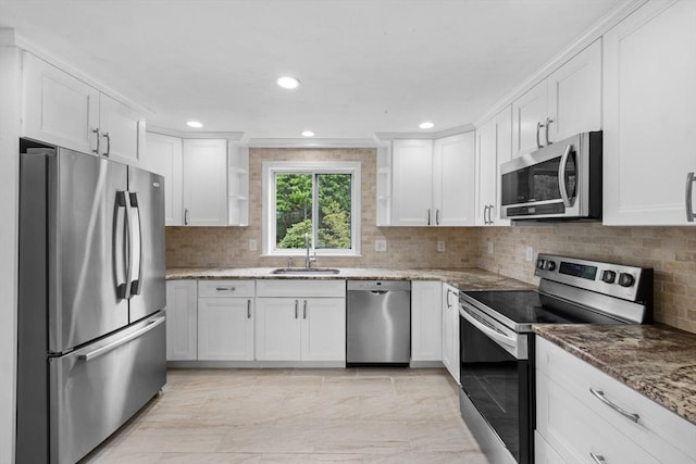 67 Great Neck Rd, Wareham, MA 02571 - kitchen featuring appliances with stainless steel finishes, a sink, white cabinetry, decorative backsplash, and light stone countertops