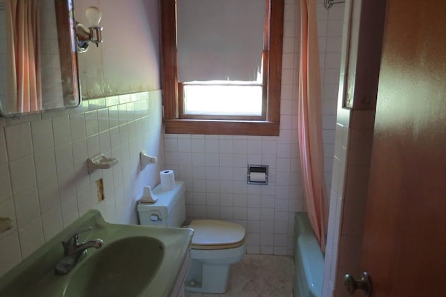 full bathroom featuring a sink, tile walls, toilet, and shower / bath combo with shower curtain