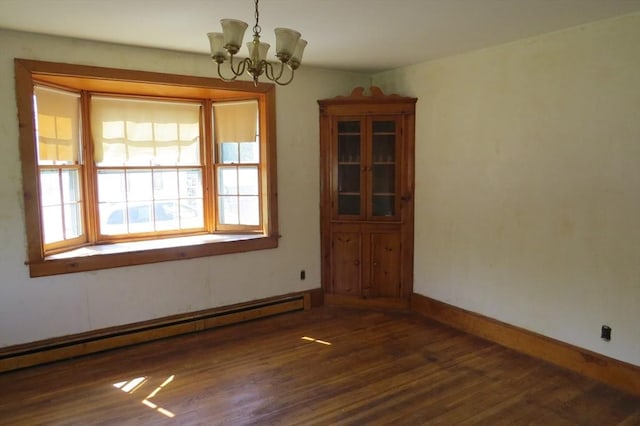 empty room with a baseboard heating unit, wood finished floors, a chandelier, and baseboards