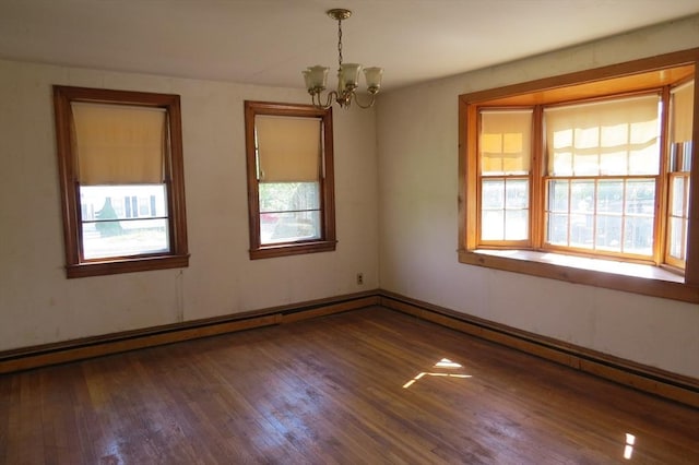 unfurnished room featuring a chandelier, wood finished floors, and a baseboard radiator