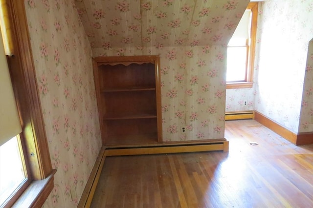 detailed view of wallpapered walls, wood finished floors, baseboards, a baseboard heating unit, and baseboard heating