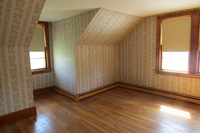 bonus room with wood finished floors, healthy amount of natural light, and baseboards
