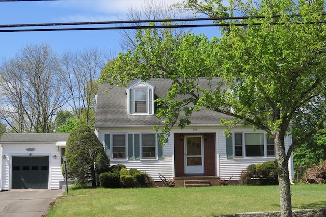 new england style home with entry steps, a front lawn, an attached garage, and concrete driveway