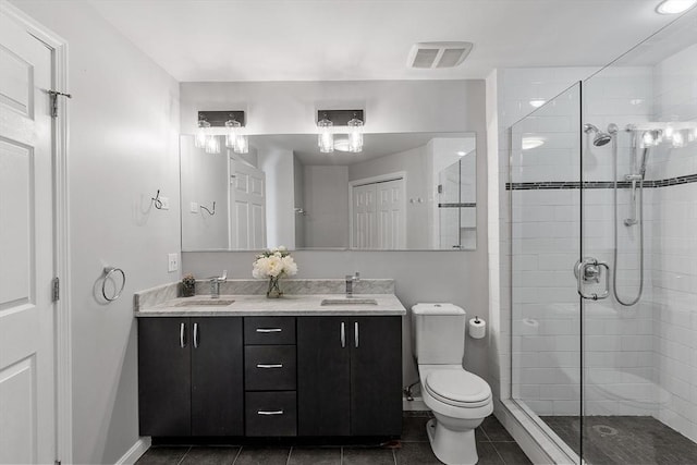 bathroom with tile patterned floors, toilet, an enclosed shower, and vanity