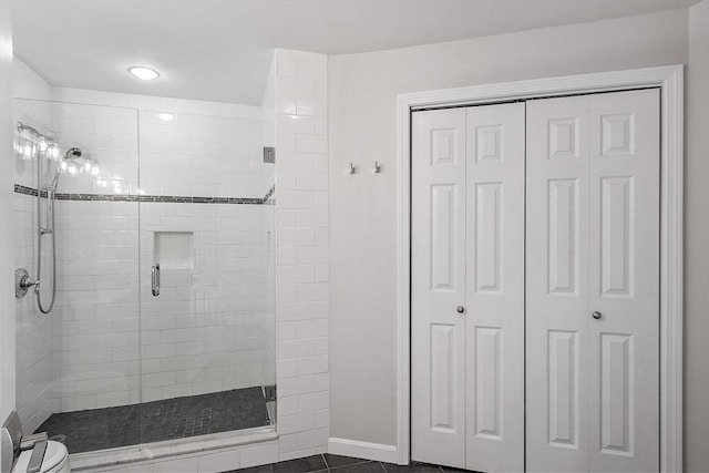 bathroom with toilet, an enclosed shower, and tile patterned flooring