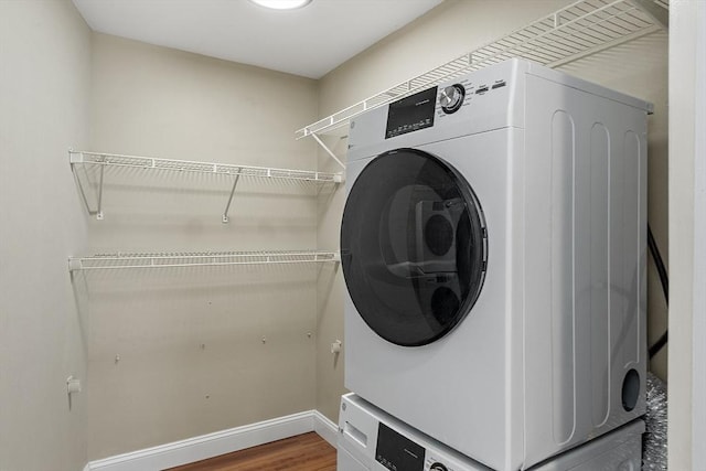 laundry room with stacked washer / drying machine and hardwood / wood-style floors