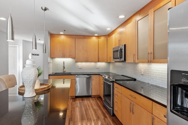 kitchen featuring pendant lighting, sink, light hardwood / wood-style flooring, stainless steel appliances, and light brown cabinetry