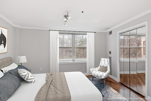 bedroom with crown molding, hardwood / wood-style floors, and multiple windows