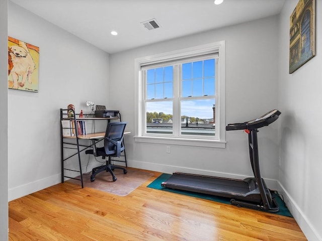 office space featuring baseboards, recessed lighting, wood finished floors, and visible vents
