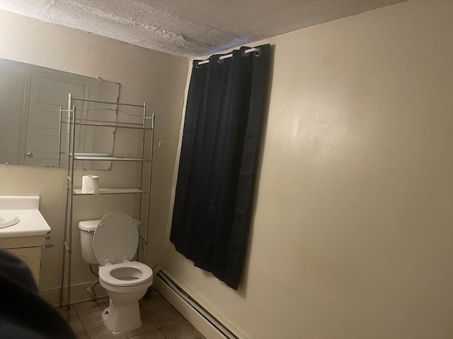 bathroom with tile patterned floors, vanity, a textured ceiling, and toilet