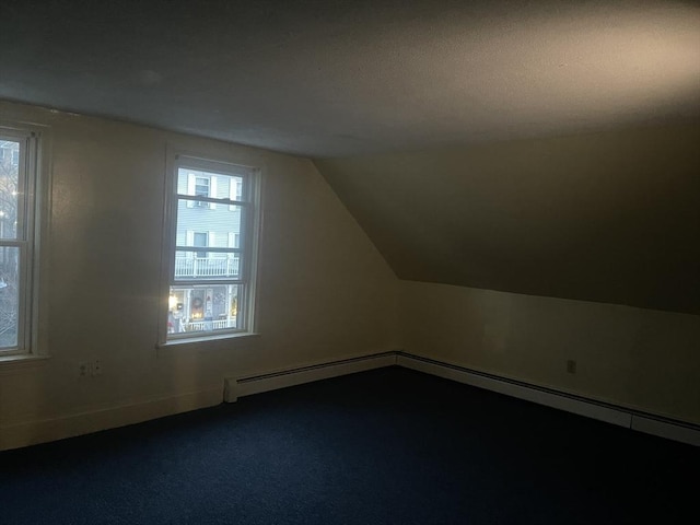 bonus room featuring carpet floors, a healthy amount of sunlight, vaulted ceiling, and a baseboard heating unit