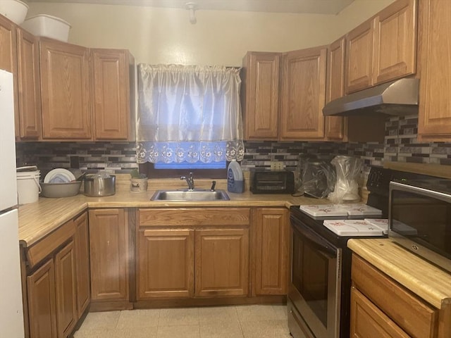 kitchen with decorative backsplash, range with electric stovetop, and sink