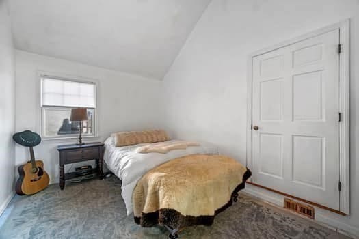 carpeted bedroom with vaulted ceiling