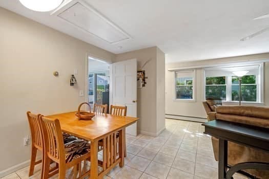 dining space featuring light tile patterned floors and a baseboard radiator