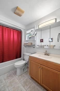 full bathroom featuring shower / bathtub combination with curtain, tile patterned floors, vanity, and toilet