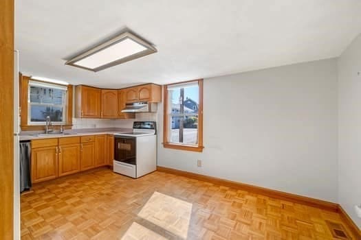 kitchen featuring stainless steel dishwasher, white range, sink, and light parquet floors