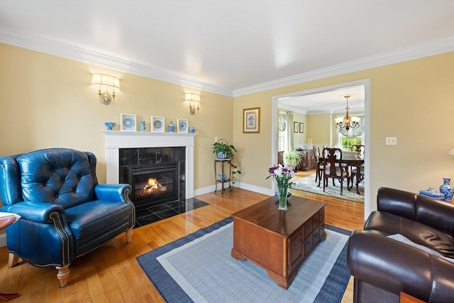 172 Orchard St, Newbury, MA 01922 - living room featuring ornamental molding, a chandelier, a tiled fireplace, wood finished floors, and baseboards