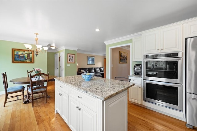 172 Orchard St, Newbury, MA 01922 - kitchen featuring stainless steel appliances, a chandelier, a kitchen island, ornamental molding, and light wood-type flooring