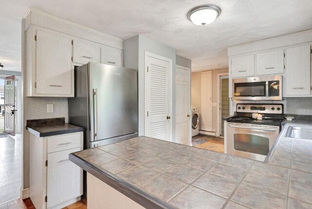 10 Emile Cir, Medford, MA 02155 - kitchen with stainless steel appliances, washer / clothes dryer, white cabinetry, and a sink