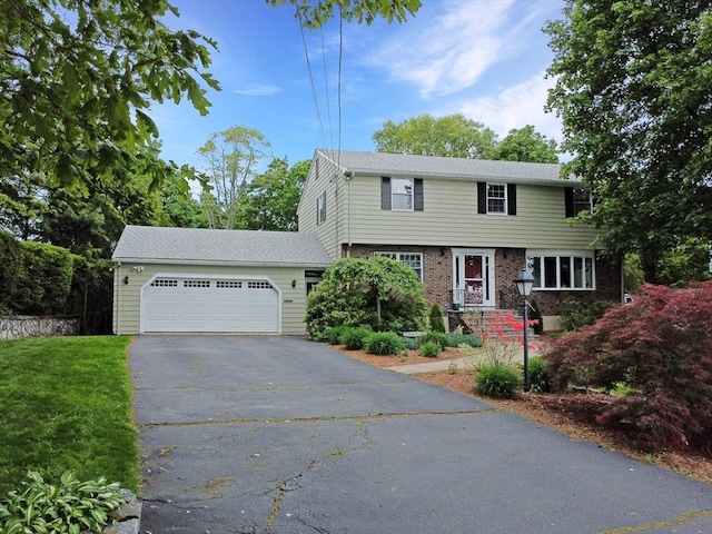 10 Emile Cir, Medford, MA 02155 - colonial inspired home with asphalt driveway, a garage, brick siding, and a front lawn