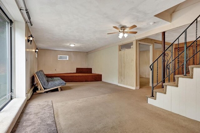 10 Emile Cir, Medford, MA 02155 - unfurnished room with carpet floors, wooden walls, a ceiling fan, and stairs