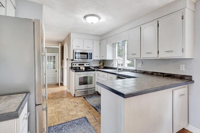 10 Emile Cir, Medford, MA 02155 - kitchen featuring appliances with stainless steel finishes, a peninsula, white cabinets, and a sink