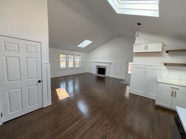 512 Lincoln St, Duxbury, MA 02332 - unfurnished living room with a skylight, a fireplace with flush hearth, a decorative wall, lofted ceiling, and dark wood-type flooring