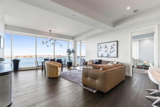 living room featuring a notable chandelier, a water view, and wood-type flooring