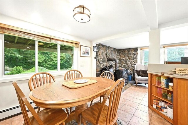 23 Westboro Rd, Upton, MA 01568 - dining space featuring a wood stove, light tile patterned floors, and baseboard heating