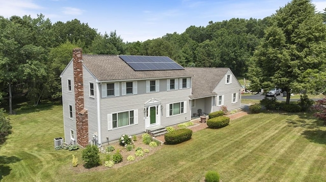 6 Boyd Dr, Newburyport, MA 01950 - colonial home featuring a chimney, roof mounted solar panels, a front yard, and roof with shingles
