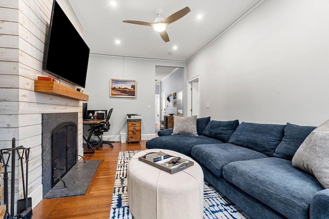 living room featuring hardwood / wood-style floors, ceiling fan, ornamental molding, and wood walls