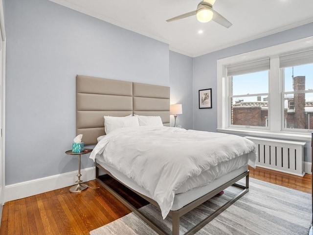 bedroom featuring hardwood / wood-style floors, ceiling fan, and crown molding