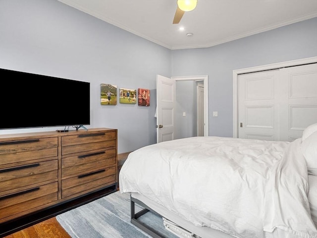 bedroom with dark hardwood / wood-style floors, a closet, ornamental molding, and ceiling fan