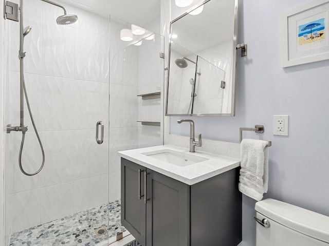 bathroom featuring vanity, toilet, and an enclosed shower