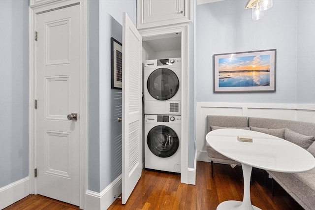 washroom featuring dark hardwood / wood-style flooring and stacked washer and clothes dryer