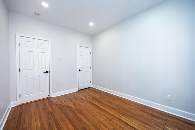 empty room with recessed lighting, baseboards, and dark wood-style floors