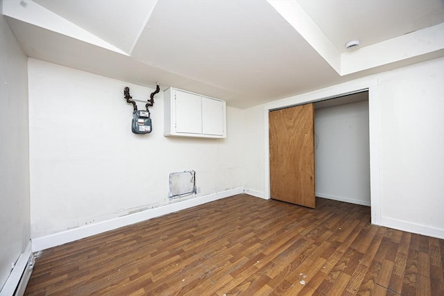 finished basement featuring a baseboard heating unit, baseboards, and wood finished floors