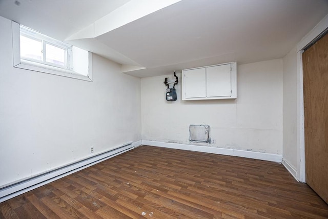 below grade area with a baseboard heating unit, baseboards, and dark wood-style floors