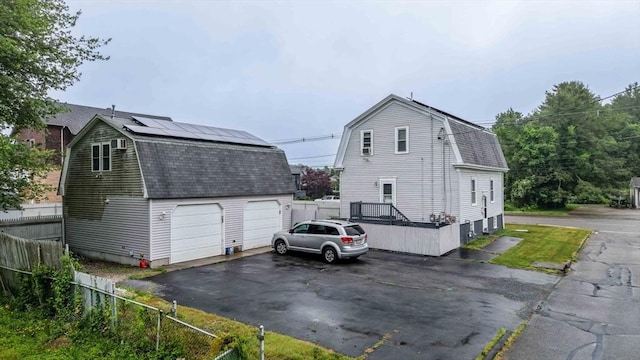 394 Huttleston Ave, Fairhaven, MA 02719 - view of home's exterior featuring a gambrel roof, an outbuilding, roof mounted solar panels, and roof with shingles