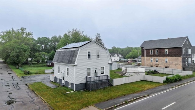 394 Huttleston Ave, Fairhaven, MA 02719 - view of property exterior featuring a gambrel roof, roof mounted solar panels, and roof with shingles