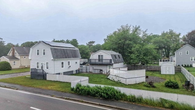 394 Huttleston Ave, Fairhaven, MA 02719 - view of front of home with a shed, a gambrel roof, a fenced backyard, and roof with shingles