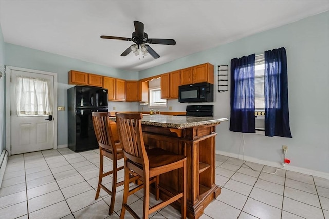 394 Huttleston Ave, Fairhaven, MA 02719 - kitchen with black appliances, light tile patterned floors, ceiling fan, brown cabinets, and a center island