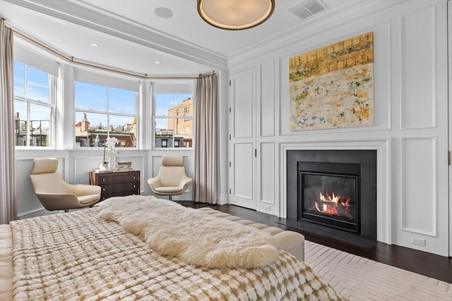 128 Marlborough St Unit 6, Boston, MA 02116 - bedroom with multiple windows, ornamental molding, a glass covered fireplace, wood finished floors, and a decorative wall