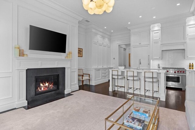 128 Marlborough St Unit 6, Boston, MA 02116 - living room featuring ornamental molding, a decorative wall, dark wood-style floors, a fireplace with flush hearth, and recessed lighting