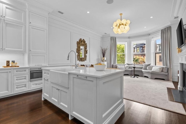 128 Marlborough St Unit 6, Boston, MA 02116 - kitchen featuring a decorative wall, ornamental molding, a sink, a chandelier, and a fireplace with flush hearth