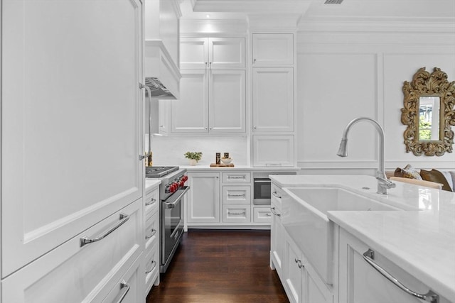 128 Marlborough St Unit 6, Boston, MA 02116 - kitchen featuring stainless steel range, a sink, light countertops, white cabinets, and ornamental molding