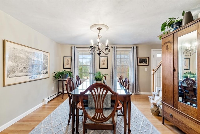 dining room featuring a baseboard heating unit, a chandelier, and light wood-type flooring