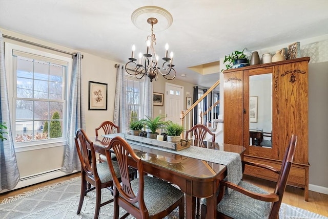 dining room featuring an inviting chandelier, light wood-type flooring, and baseboard heating